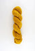 Mustard yellow skein of yarn on a white background