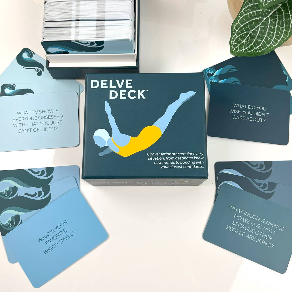 Delve Deck card game box with cards spread out on a light surface.