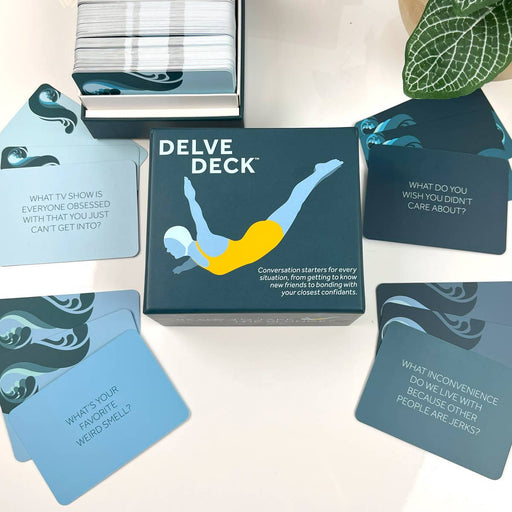 Delve Deck card game box with cards spread out on a light surface.