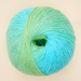 Ball of yarn with a gradient from green to blue on a beige background