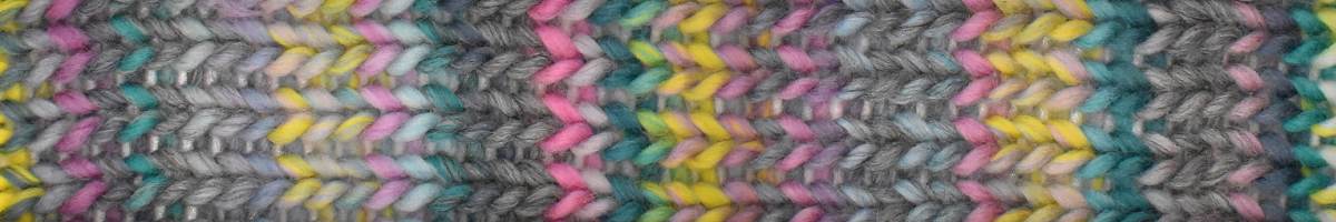 Close-up of a colorful woven pattern with shades of gray, pink, yellow, and green.