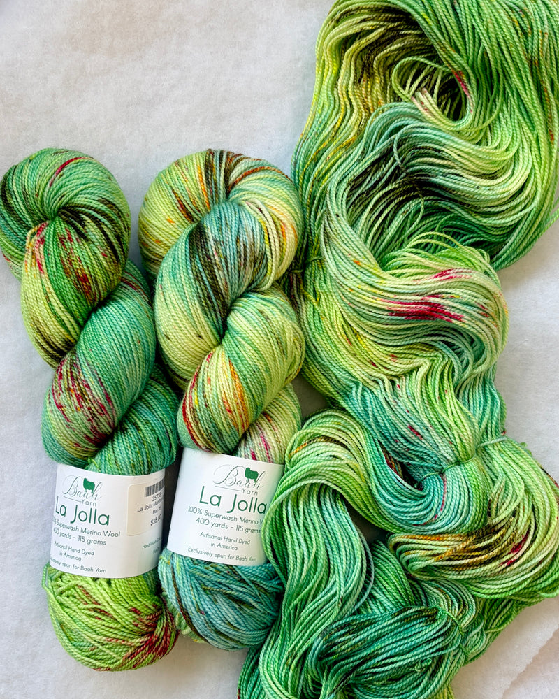 Three skeins of green yarn with speckles, labeled 'La Jolla', on a light background.