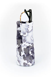 Snakeskin-patterned wine bottle holder with a black hair clip on a white background