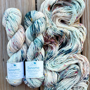 Three skeins of yarn with 'Sonoma' labels on a wooden background