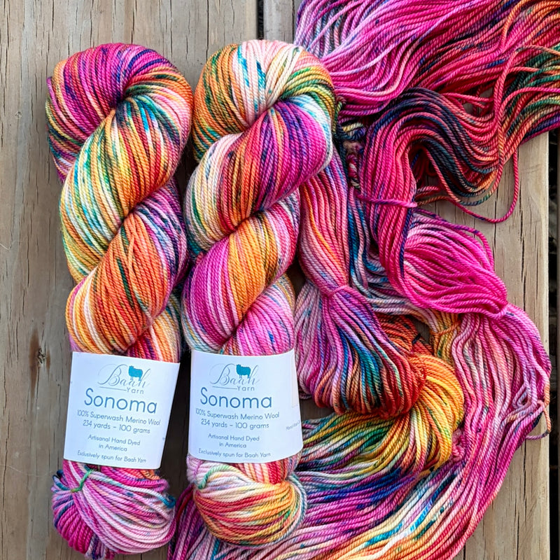 Colorful skeins of yarn with labels on a wooden background