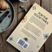 Back of Book titled 'For the Good Times' on a wooden surface with a plate of food.
