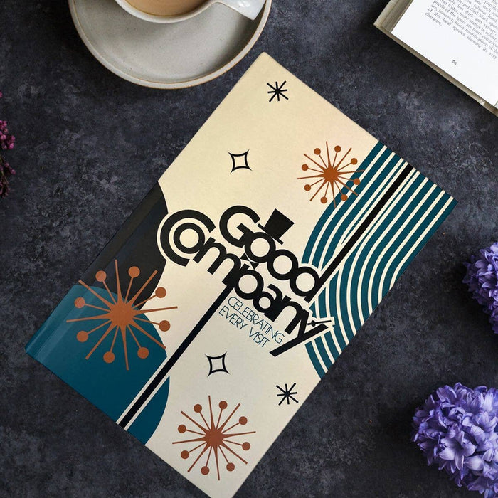 Good Company book with decorative cover on a dark surface with flowers and a cup.