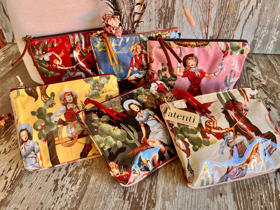 Set of six colorful pouches with vintage-cowgirl designs on a wooden surface