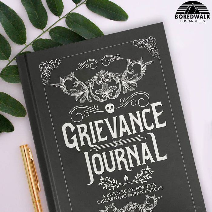Grievance Journal book with decorative cover and gold pen on a light background