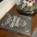 Grievance Journal book on a wooden surface with decorative skull and butterfly in the background