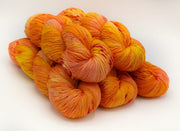Stack of orange and yellow yarn on a white background