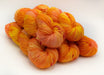 Stack of orange and yellow yarn on a white background