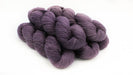 Three skeins of purple yarn on a white background