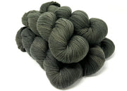 Dark gray skeins of yarn stacked on a white background