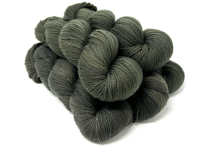 Dark gray skeins of yarn stacked on a white background