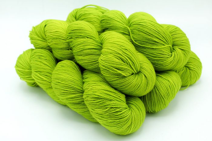 Bunch of bright green yarn on a white background