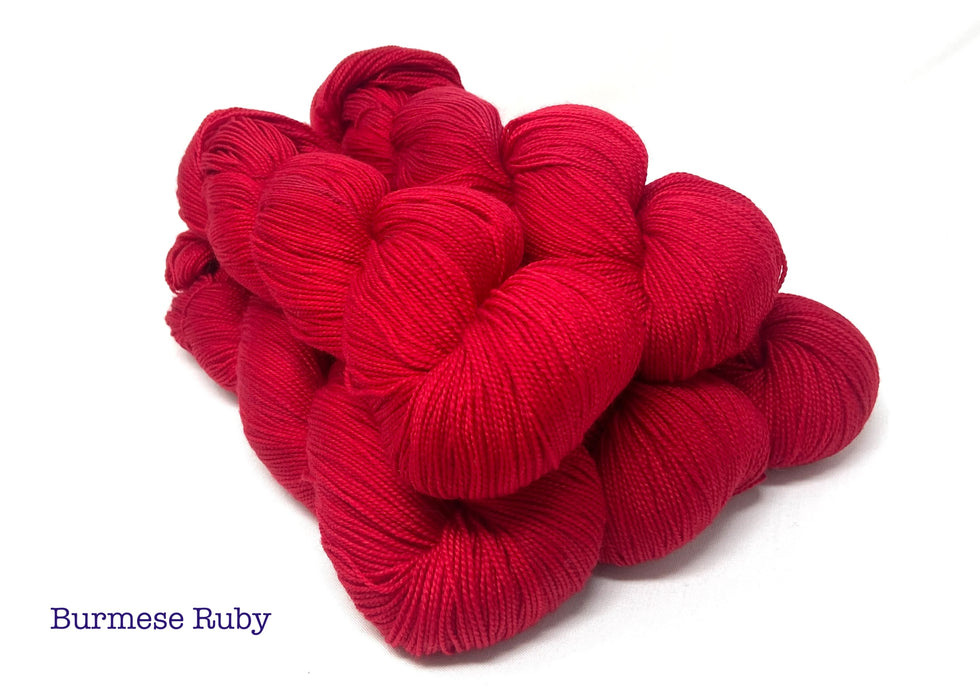 Red yarn on a white background with the words "Burmese Ruby"