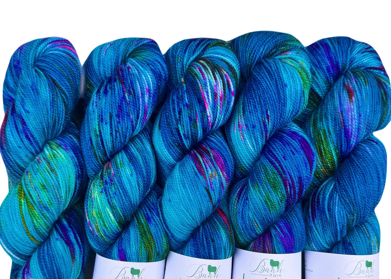 Blue skeins of yarn with colorful speckles on a white background
