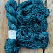 Blue skein of yarn with a label on a wooden surface