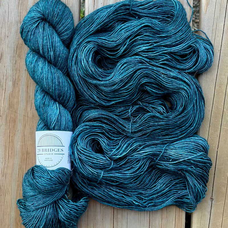 Blue skein of yarn with a label on a wooden surface