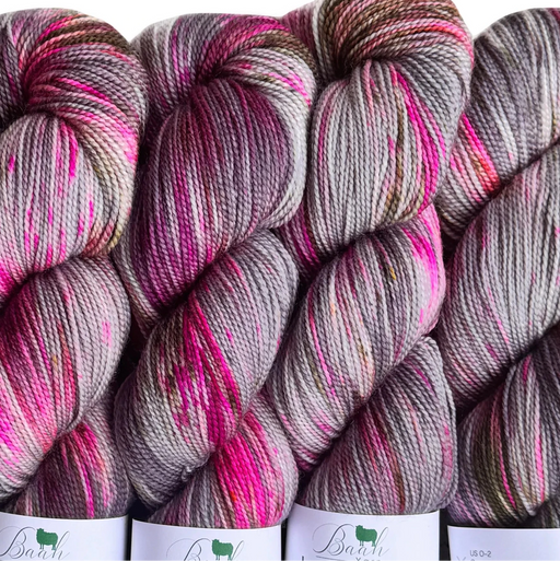 Three skeins of multicolored yarn with pink and gray patterns on a white background.
