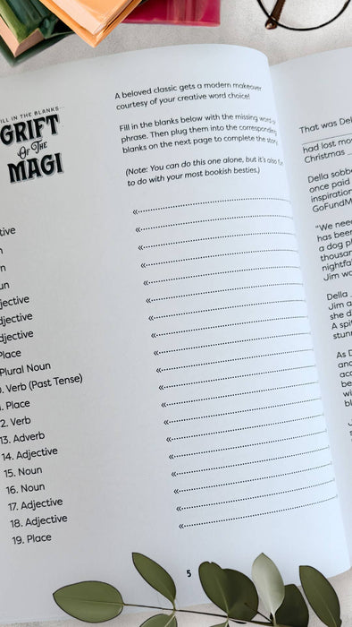 Open book with a blank fill-in-the-blank exercise on a white surface with green leaves.