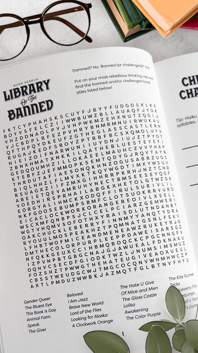 Open book with text and a pair of glasses on a surface