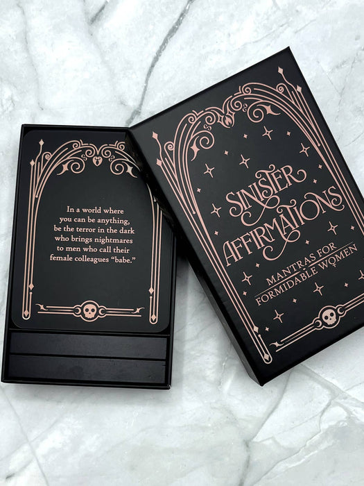 Black card deck with decorative text on a marble surface