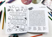 Open book with coloring page and word search on a table with stationery items