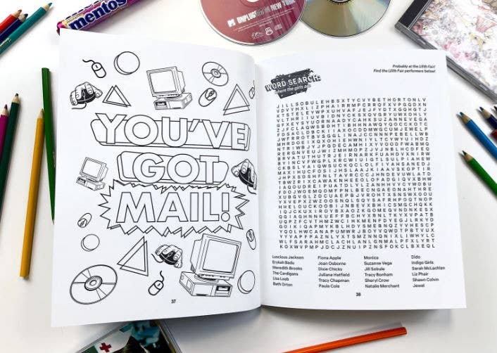 Open book with coloring page and word search on a table with stationery items