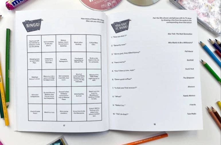 Open book with a bingo-style game on a table with colored pencils